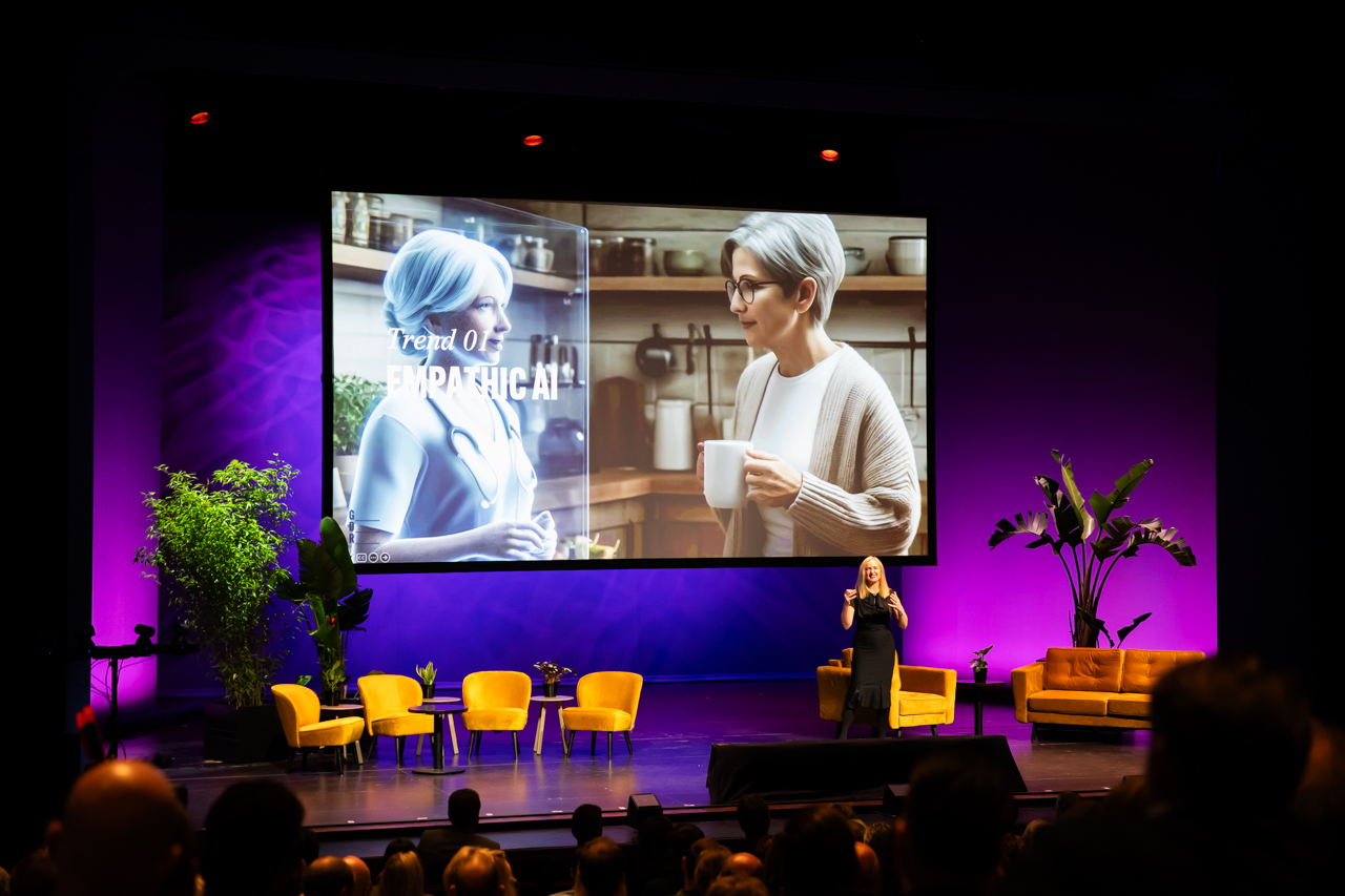 Kate Ancketill delivering a keynote at RetailTrends Netherlands, with Empathic AI on screen